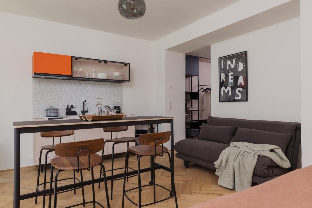 cocina y sala de estar con bar y sofá en Marktbar Studios - Boutique Aparthotel en Innsbruck