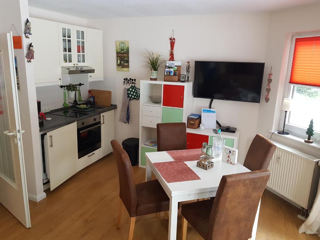 cocina y comedor con mesa y sillas en Apartment Kleiner Heinrich, en Braunlage