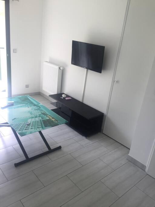 Habitación con mesa y TV en la pared. en Studio meublé. Proche mer et centre ville en Niza