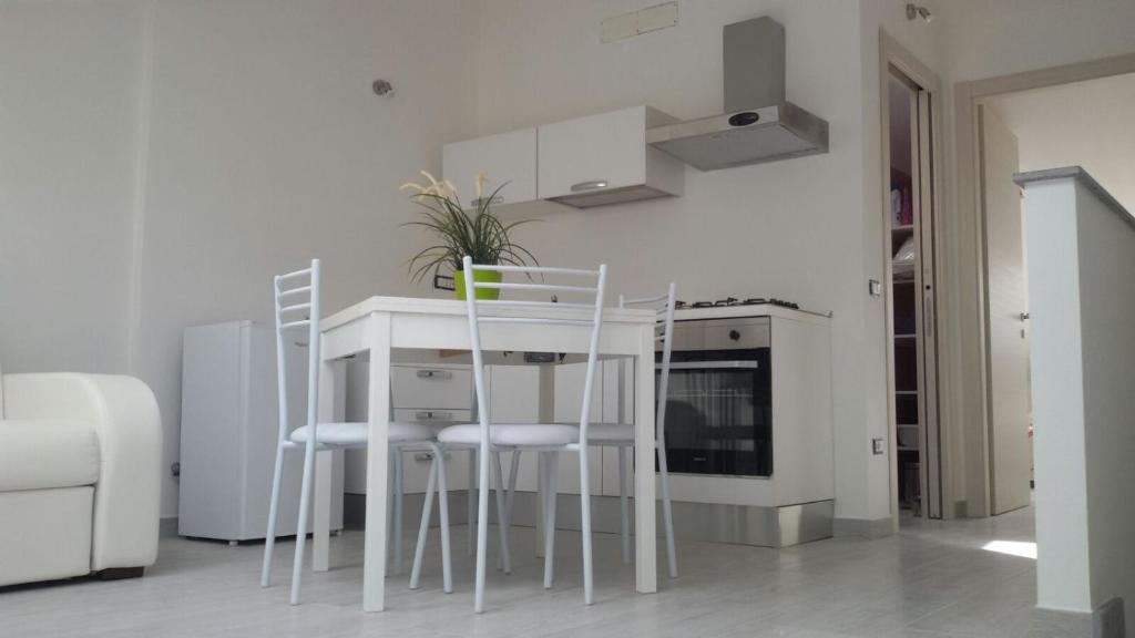een keuken met een tafel en stoelen in een kamer bij Casa Lorenzo&Luca in Gonnesa