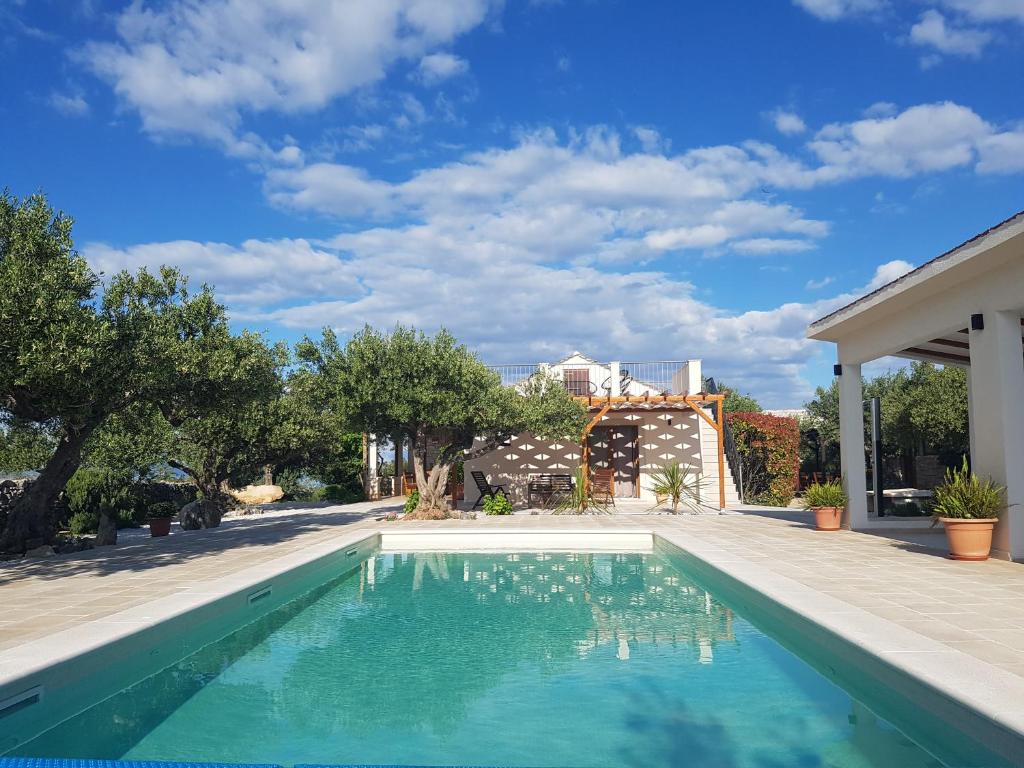 uma piscina no quintal de uma casa em Stone Villa Olea - Holiday house in olive grove em Supetar