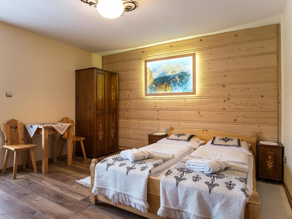 a bedroom with two beds in a wooden wall at Willa Daglezja in Zakopane