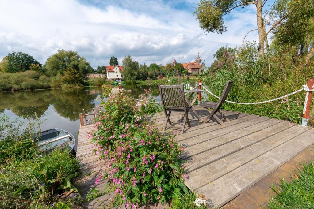 a bench sitting on a wooden dock next to a lake at Ferienwohnungen Schiffstatt in Guxhagen