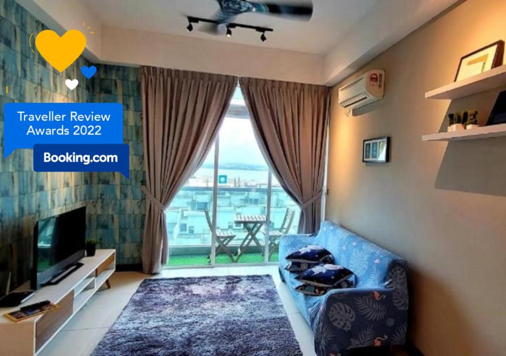 un salon avec un canapé bleu et une télévision dans l'établissement Experience the Coast - HostaHome Suites at Paragon Residence near Downtown, à Johor Bahru