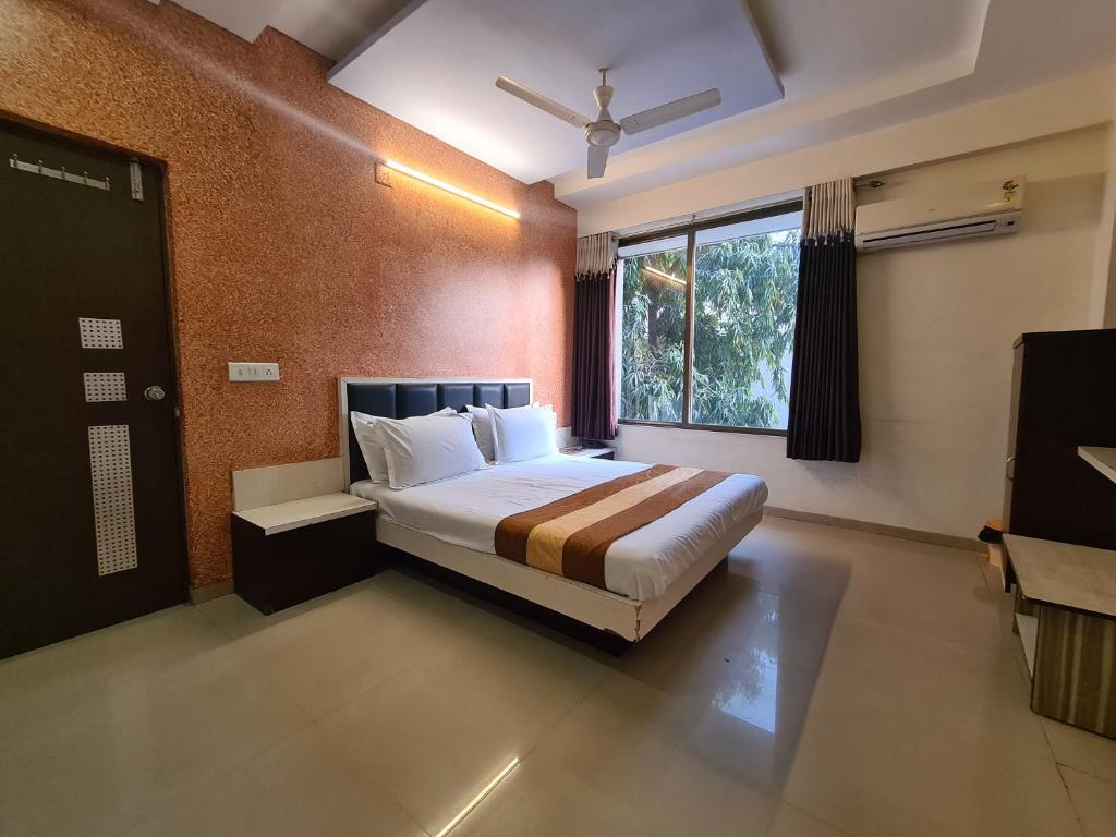 a bedroom with a bed and a large window at Hotel Nova Sun in Ahmedabad