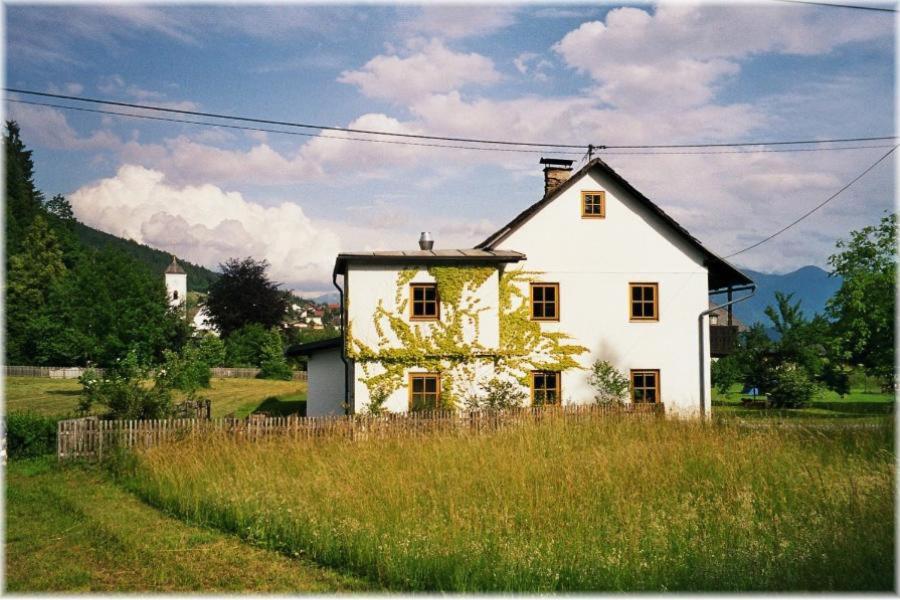 een wit huis in het midden van een veld bij Ferienwohntraum Haller in Nötsch