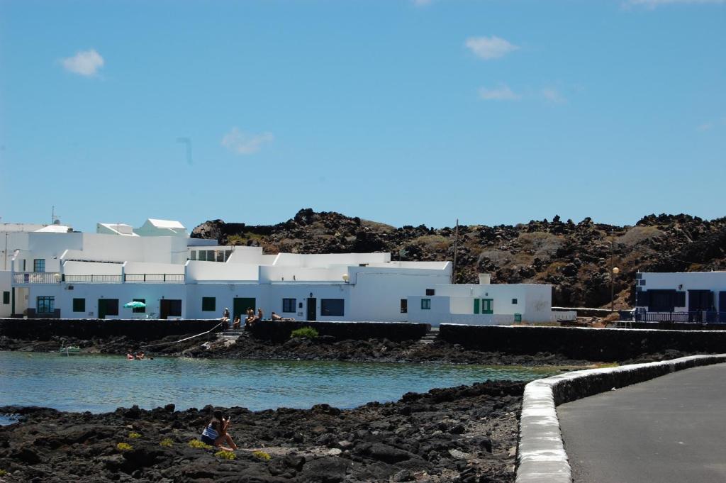 a group of people swimming in the water in front of buildings at Tranquilo y Acogedor Apartamento in Órzola