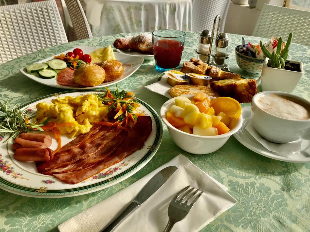 a table with plates of breakfast food on it at Hotel Stefania Boutique Hotel by the Beach in Olbia