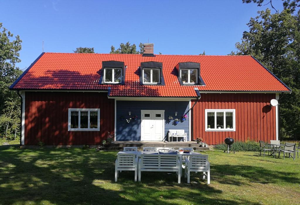 a red house with a table in front of it at Bolmen Bed - Vandrarhem in Ljungby