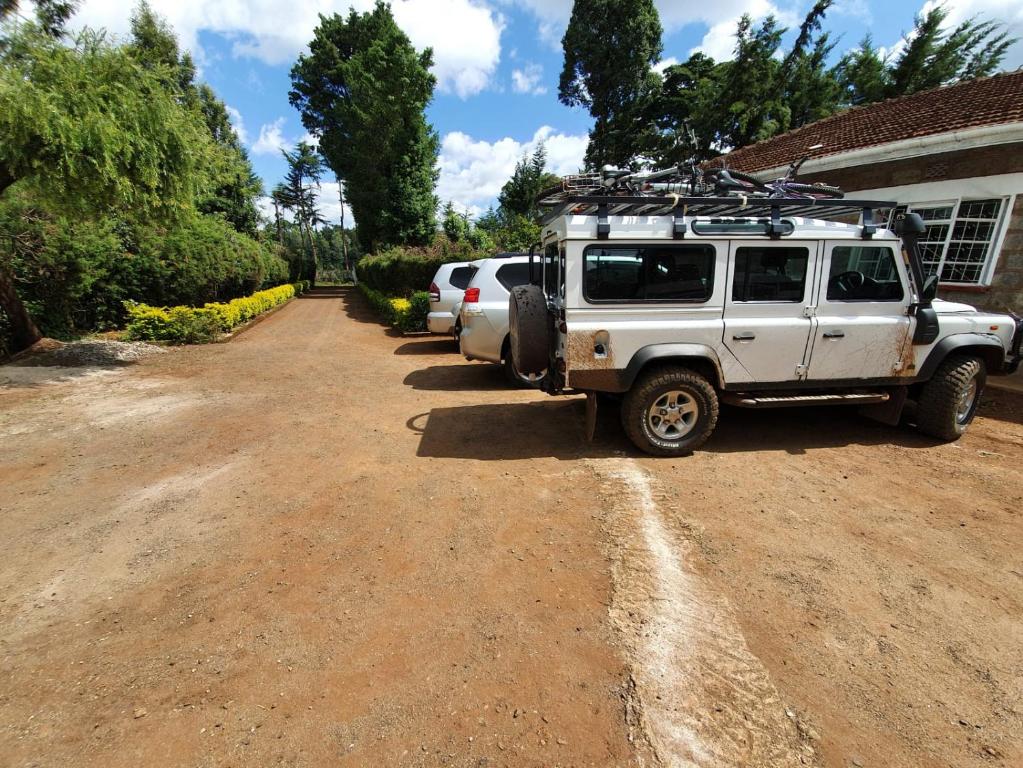 a white jeep parked on a dirt road at Thayo Place in Nyeri