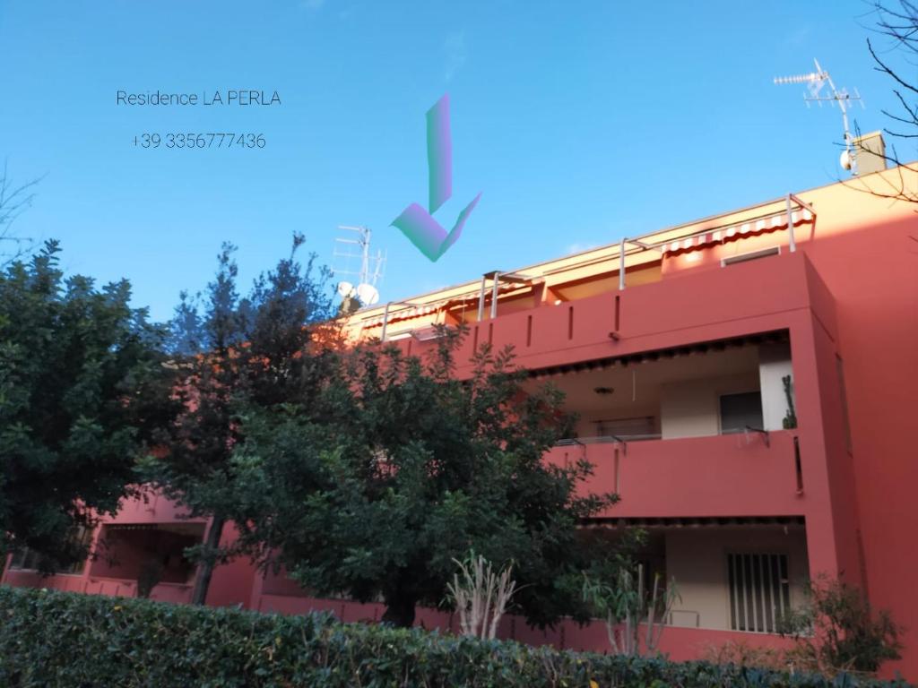 La Perla di Alghero في ألغيرو: مبنى بسهم اخضر مشيرا الى مبنى