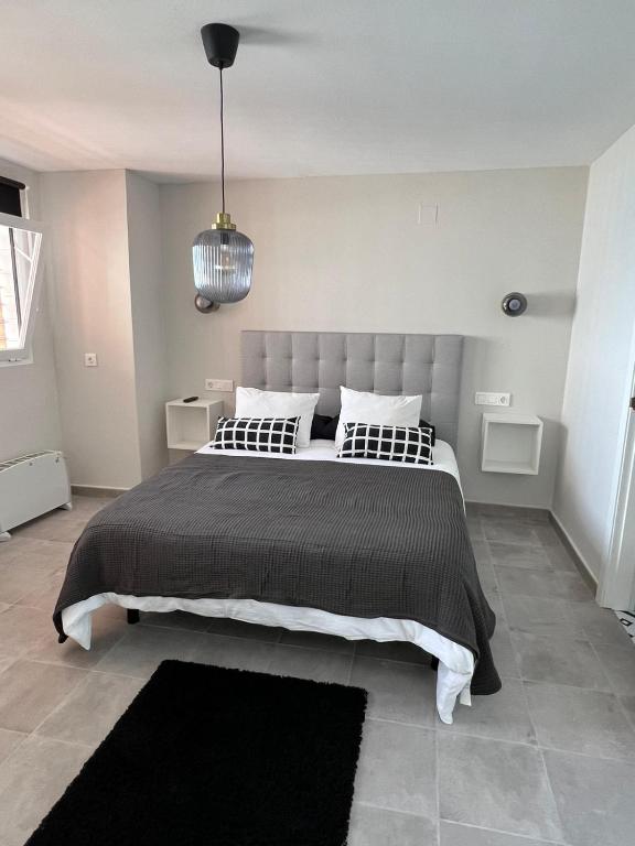 a bedroom with a large bed with a black blanket at Apartamentos La Mar in Altea