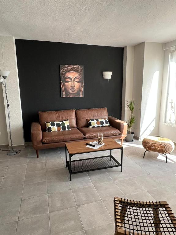 a living room with a brown couch and a table at Apartamentos La Mar in Altea