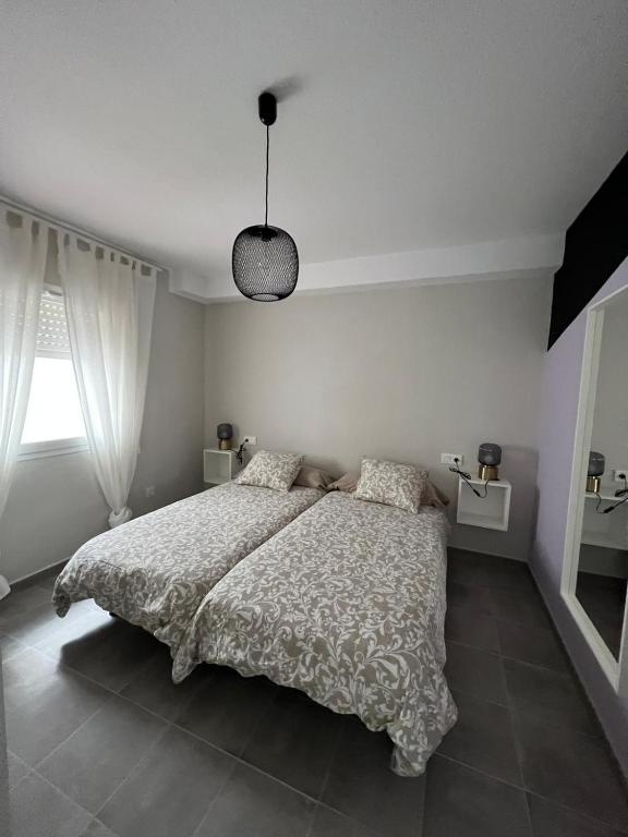 a bedroom with a bed and a pendant light at Apartamentos La Mar in Altea