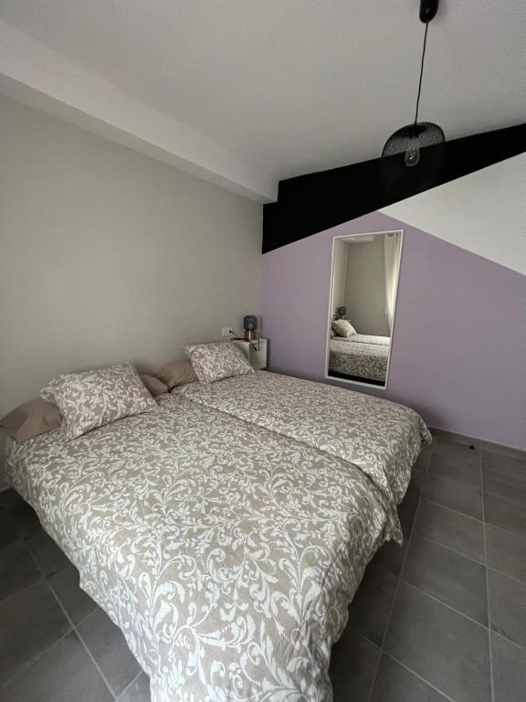 a bedroom with a large bed and a mirror at Apartamentos La Mar in Altea