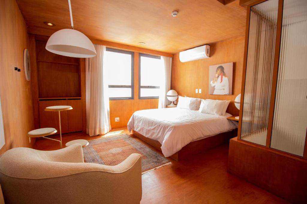 a bedroom with a bed and a chair in it at Hotel Centro 433 in São Paulo