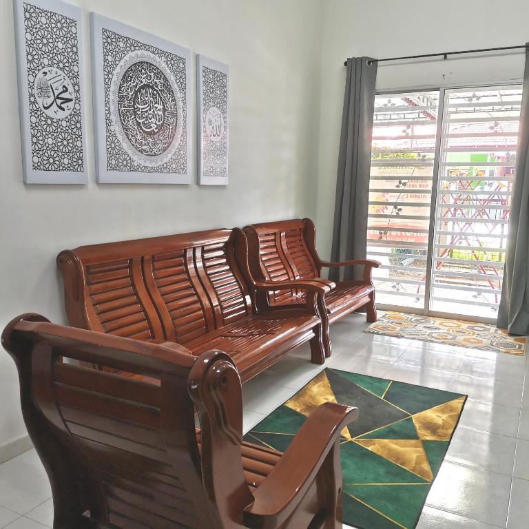 a living room with two chairs and a couch at Homestay Inap Bakawali Seri Iskandar in Seri Iskandar