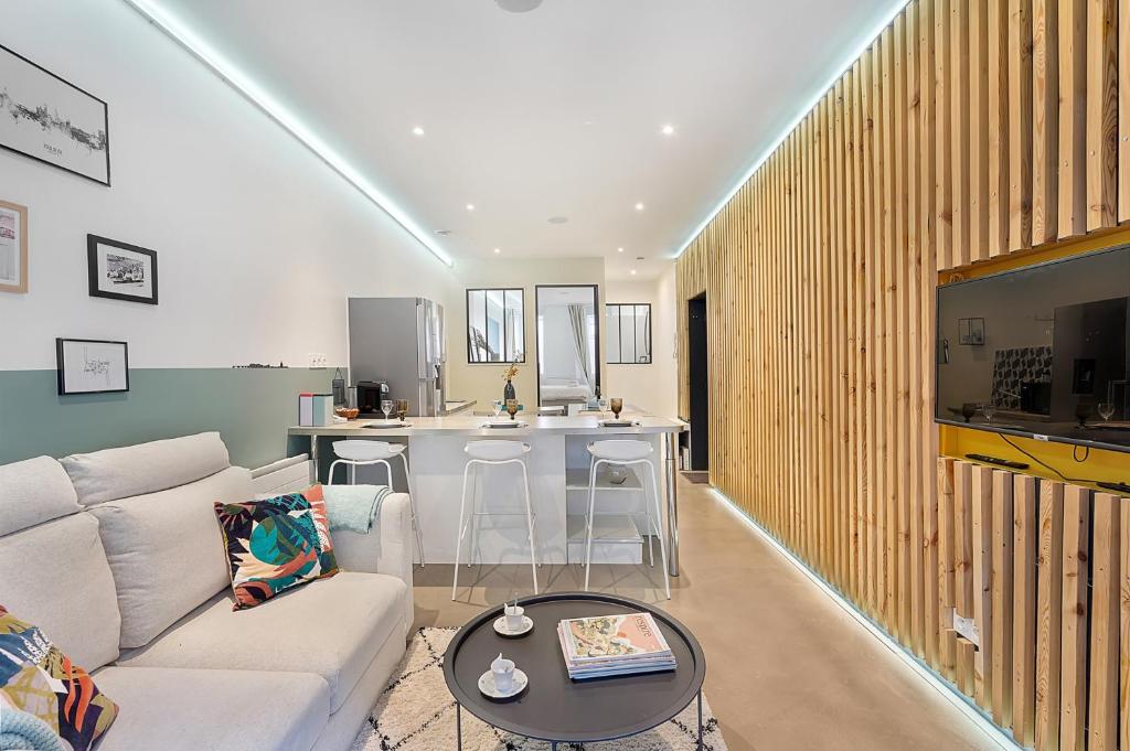 un salon avec un canapé blanc et une table dans l'établissement LE PHARE - au cœur du quartier des chalets, à Toulouse