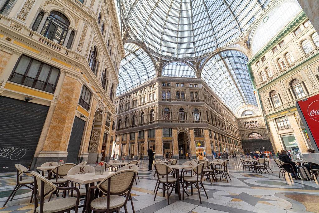 duży budynek ze stołami i krzesłami oraz szklanym sufitem w obiekcie PC Boutique H, Sea View by ClaPa group w mieście Neapol