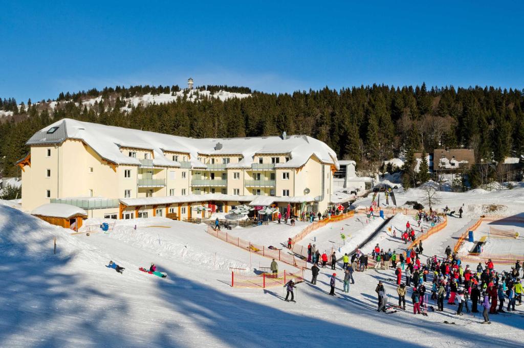 a group of people standing in the snow in front of a ski lodge at H&P Touristik Residenz Grafenmatt GRA-1-1 in Feldberg