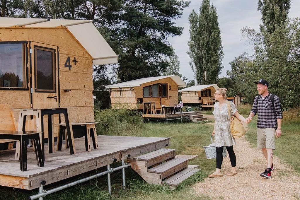 a man and woman holding hands in front of a tiny house at destinature Dorf Hitzacker in Hitzacker