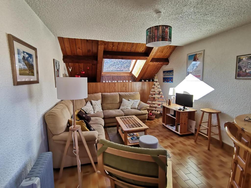 a living room with a couch and a table at APPARTEMENT T3 60M2 à Briançon dans résidence calme avec 7 couchages in Briançon