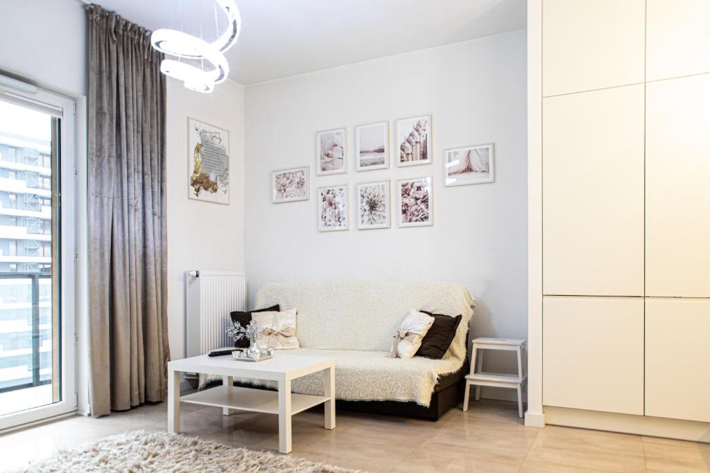 a white living room with a couch and a table at Wola Glamour Apartment in Warsaw