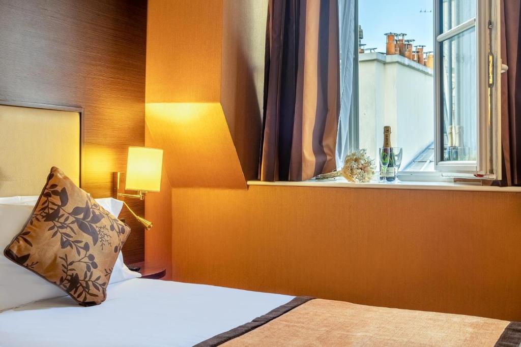 une chambre d'hôtel avec un lit et une fenêtre dans l'établissement Hôtel 85 Saint Honore, à Paris