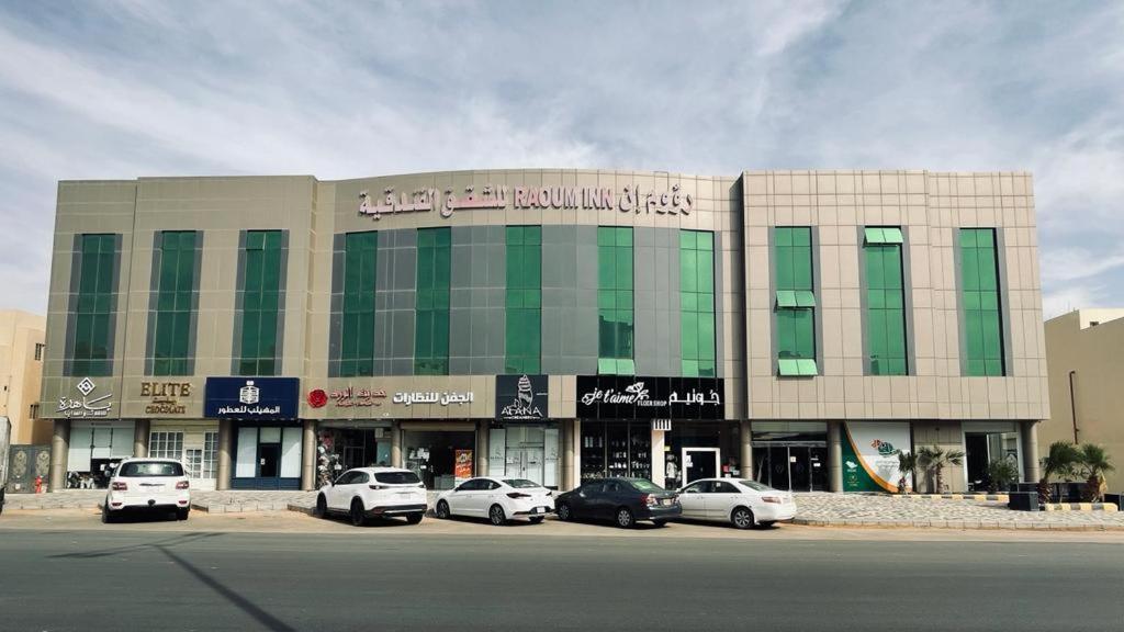 un grande edificio con macchine parcheggiate di fronte di Raoum Inn Buraydah a Buraydah