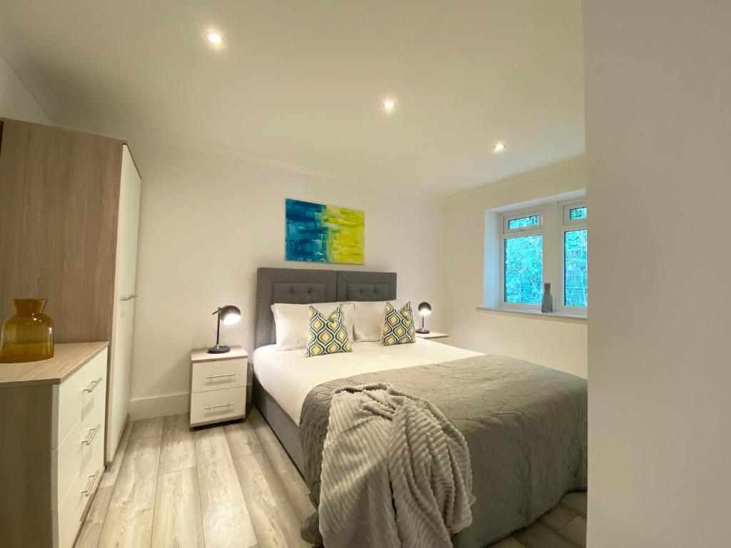 a white bedroom with a bed and two windows at 2 Bedroom Holiday Home near Bolton, Appleby-in-Westmorland in Kirkby Thore