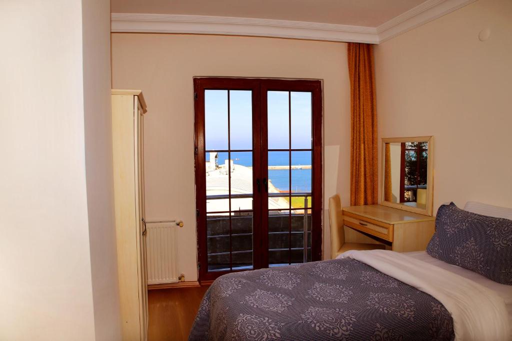 a bedroom with a bed and a view of the ocean at Miletus Otel Şile in Şile