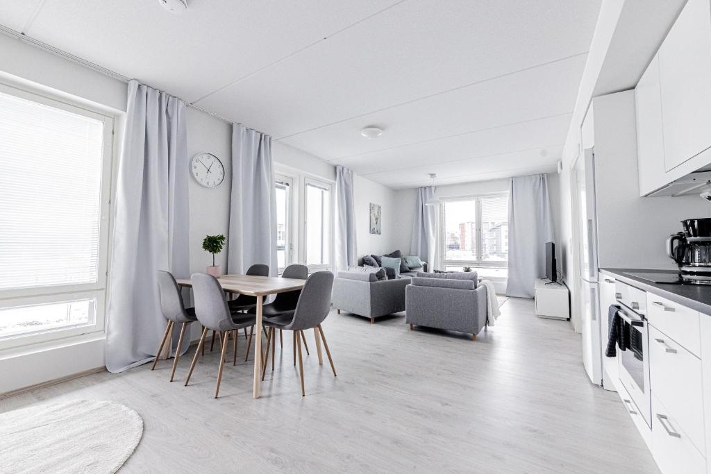 a kitchen and living room with a table and chairs at Apartment, SleepWell, Nuutti in Turku