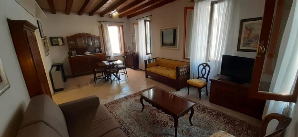 uma sala de estar com um sofá e uma mesa em Ca' del Forner em Veneza