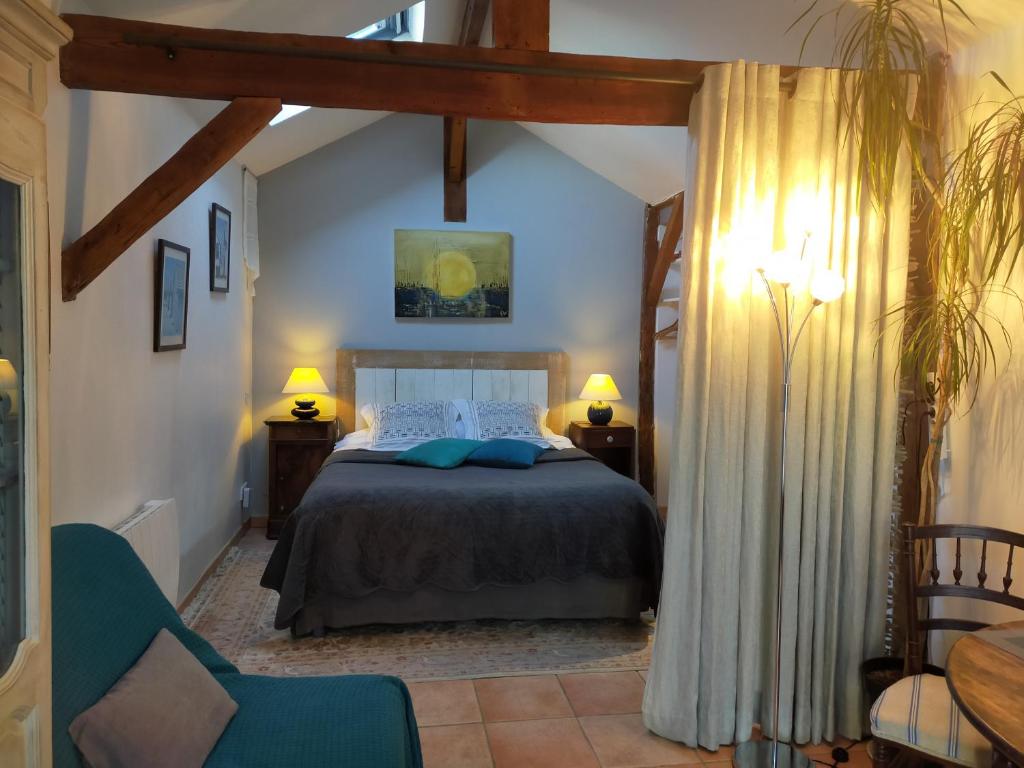 sypialnia z łóżkiem, stołem i krzesłami w obiekcie Chambres d'hôtes du Parc d'Espagne w mieście Pessac