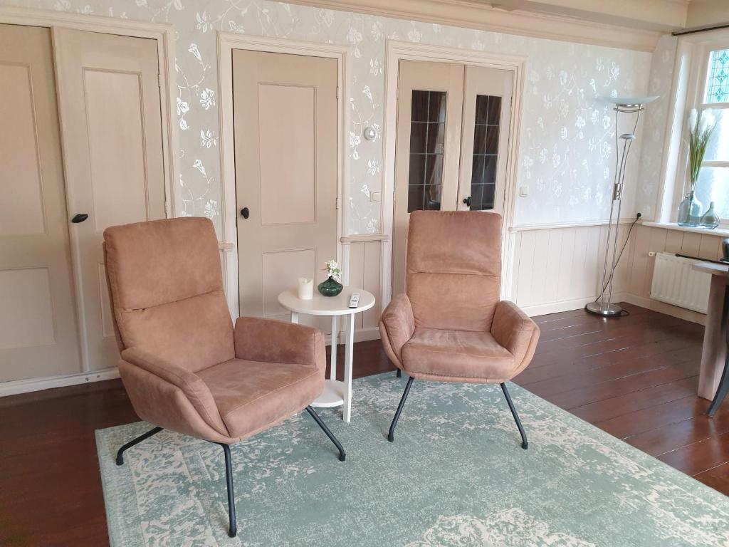twee stoelen en een tafel in de woonkamer bij Vakantiehuis Doelestee in Balk