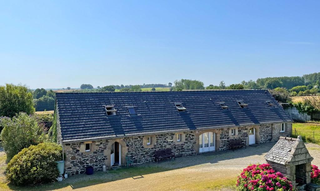 an old stone house with solar panels on its roof at Lescoat-le petit paradis in Plestin-les-Grèves