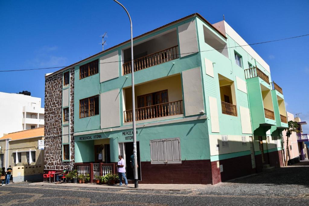 a person standing in front of a colorful building at Residencial Vitoria in Ponta do Sol