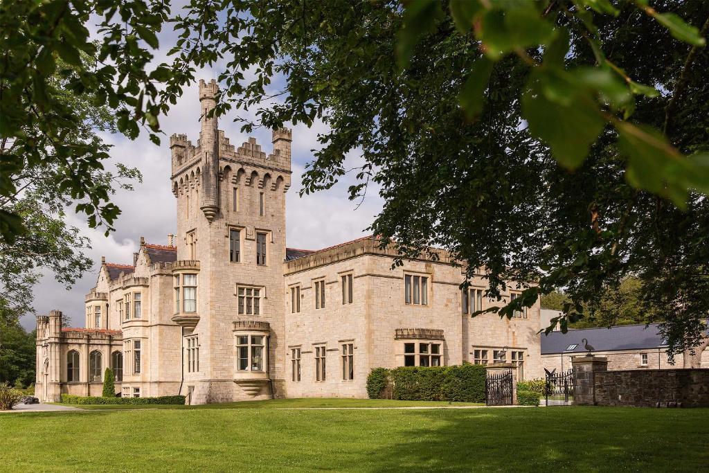 a large building with a clock on the front of it at Lough Eske Castle in Donegal