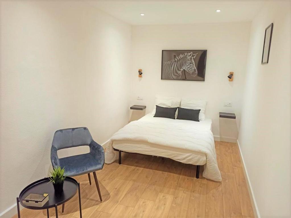 una camera da letto con un letto e una sedia blu di L'auberge aux volets rouges à 4 min du Zoo de Beauval 2-10 pers a Saint-Aignan