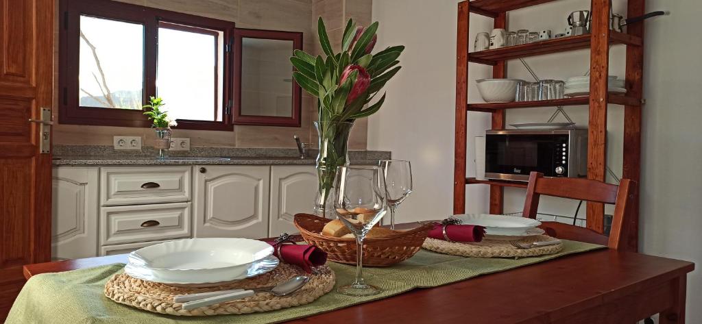 una mesa con platos y una copa de vino. en Casa Ada en Tejeda