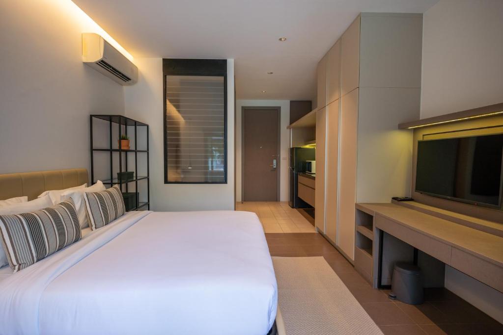 A neatly arranged bedroom with built-in storage, television and air conditioning.