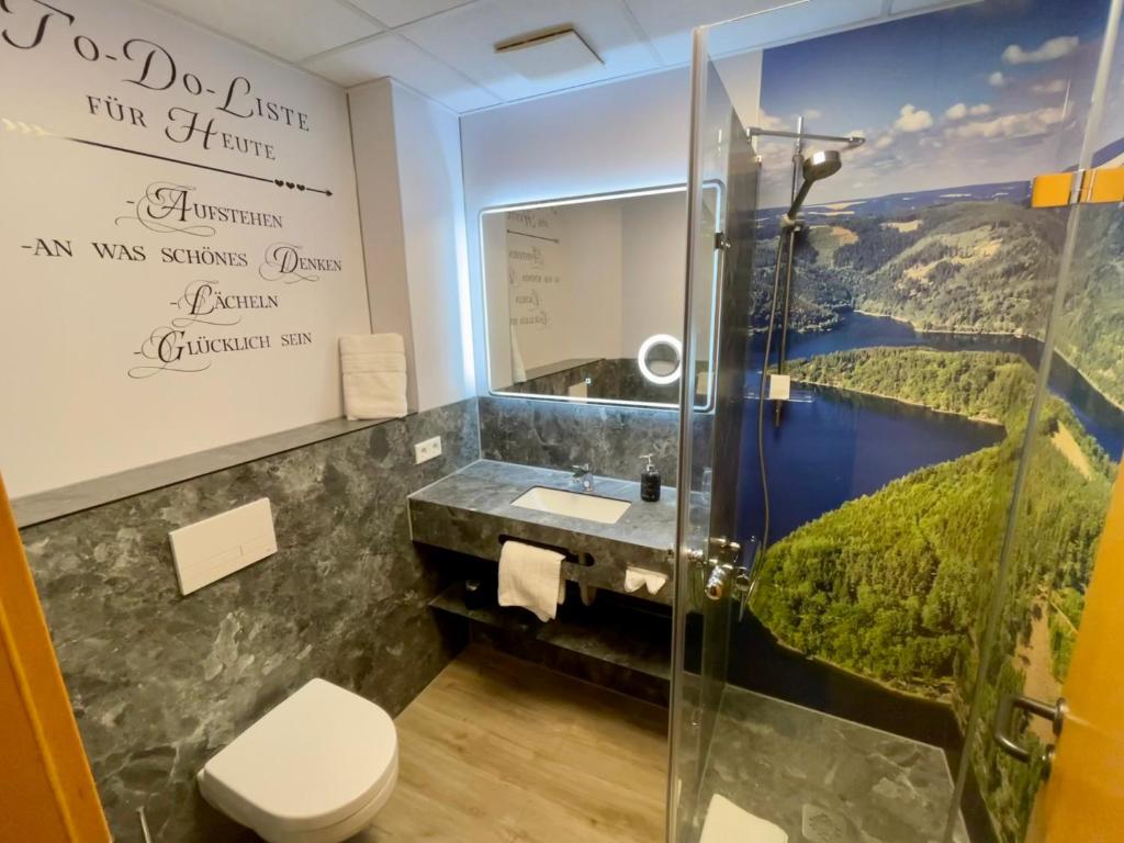 a bathroom with a shower and a sink and a mirror at Hotel &amp; Restaurant Bergfried in Saalfeld