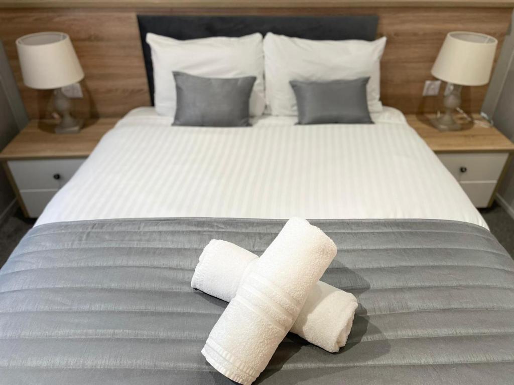 a bed with two rolled towels on top of it at Beryl Lodge with Hot Tub in York