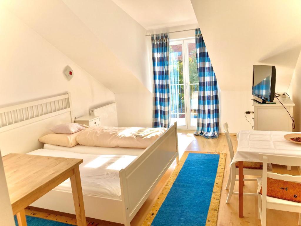 a bedroom with a bed and a table and a tv at Gästezimmer Puzwidu in Vienna
