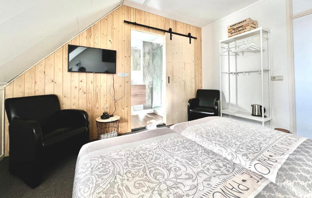 sypialnia z łóżkiem, 2 krzesłami i telewizorem w obiekcie B&B Hartje Spakenburg w mieście Spakenburg