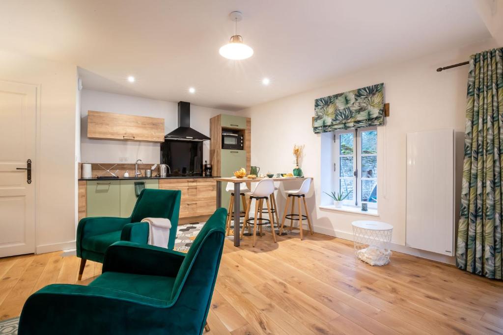 a kitchen and living room with green chairs and a table at Villa Fémina in Savigny-lès-Beaune