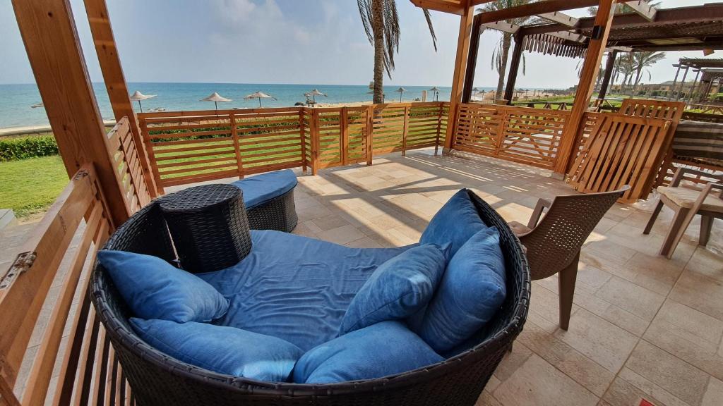 a hammock chair sitting on a patio with the beach at Breathtaking Luxury & Spacious 2-Bedroom 1st Row Direct Seaview at Stella Sea View Sokhna in Ain Sokhna