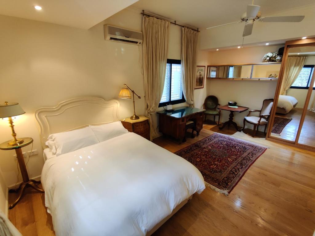 een slaapkamer met een wit bed en een woonkamer bij Yarden Deluxe Studio Suite in Tel Aviv