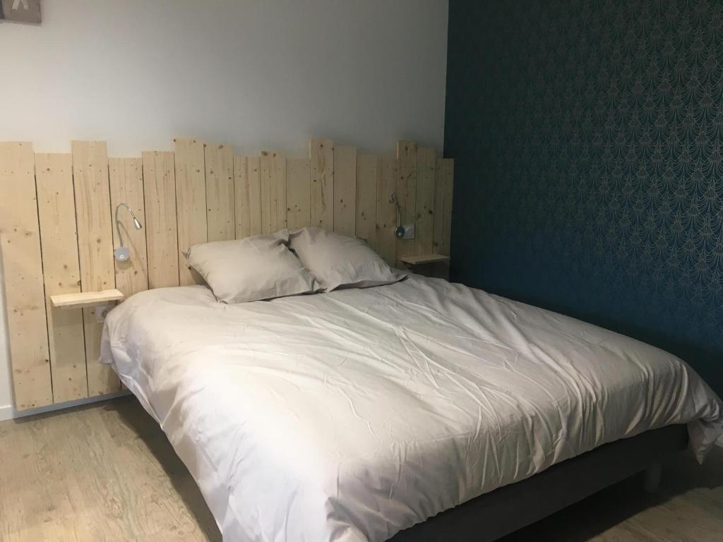 uma cama num quarto com uma parede de madeira em Au boitissandeau em Saint-Paul-en-Pareds