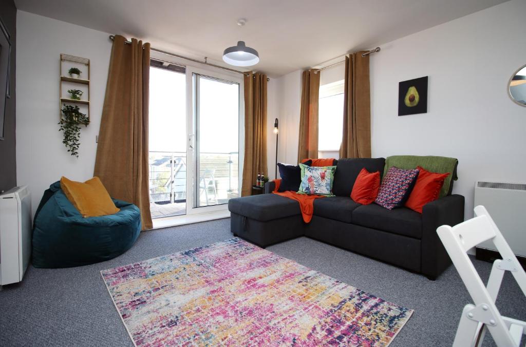 a living room with a black couch and a rug at Penners Place by Tŷ SA in Newport